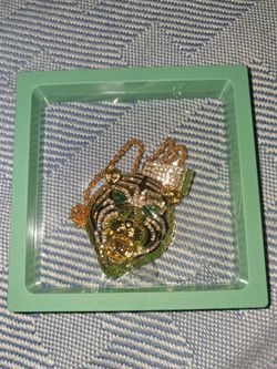 14k gold plated over stainless steel nice tiger with green cz and cz around the mane comes with a 14 k plated over a stainless steel 26 inch chain