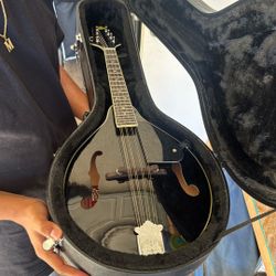 This is a black A-style acoustic mandolin a Rogue RM-100A