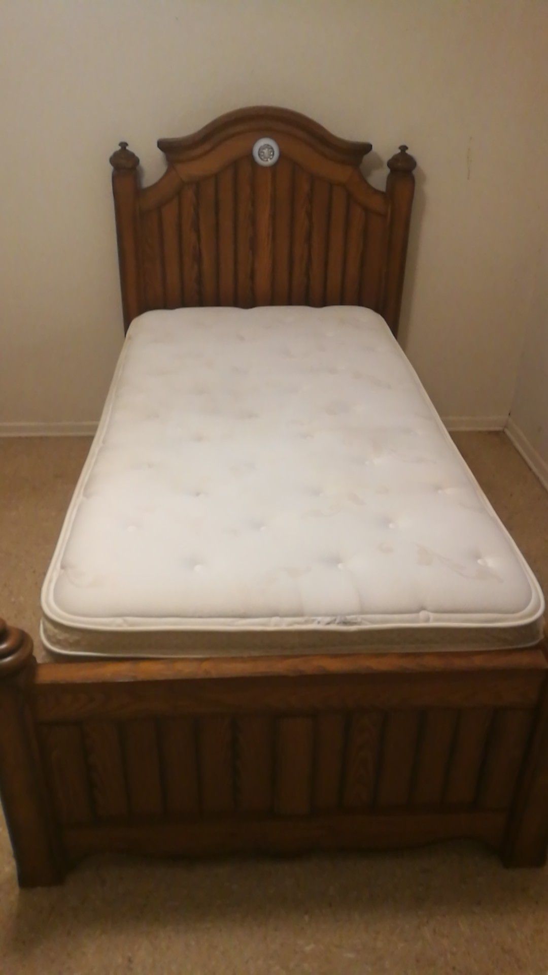 Solid wood twin bed frame with mattress.
