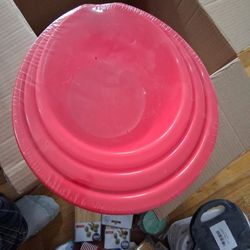 The set includes three red nesting mixing bowls.
The bowls feature a spout for pouring.
They are used for kitchen creations and baking.