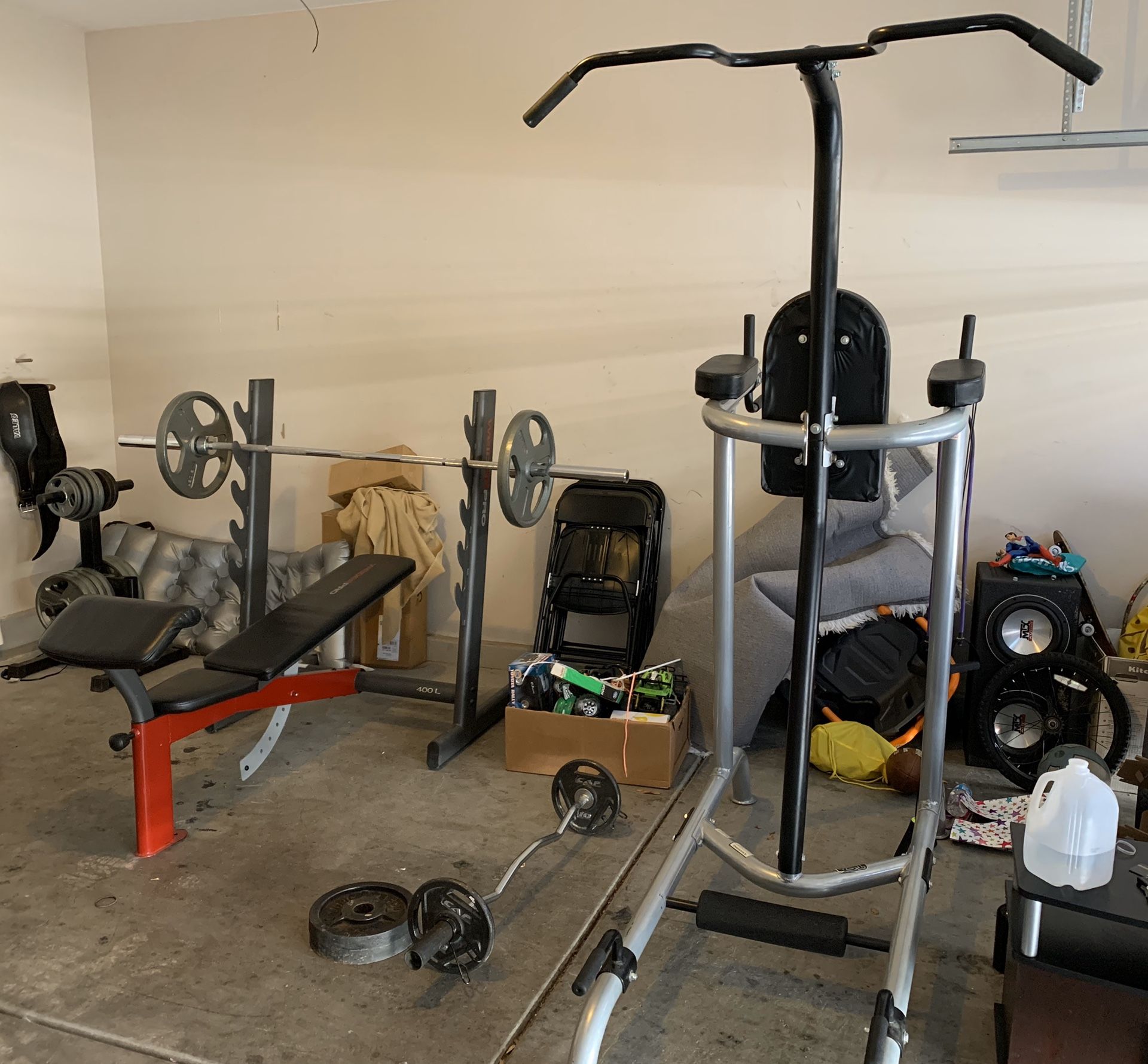 Gym equipment. Bench press, curl bar, pull up and dip set with weight rack.