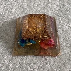 pyramid crafted from resin, metal filings, and crystals used for spiritual practices Orgonite pyramid crafted from resin, metal filings, and crystals