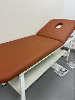 brown adjustable salon massage therapy bed with a facial hole