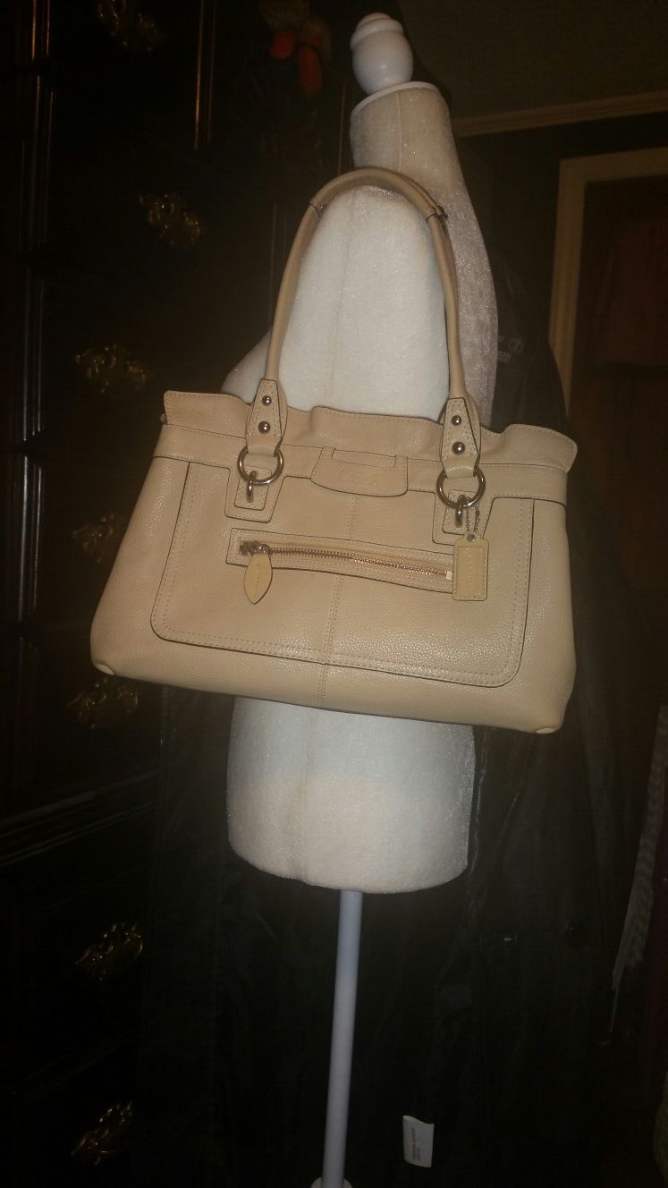 Leather Coach pocketbook with large compartments inside and zipper pockets and a front zipper pocket on the outside