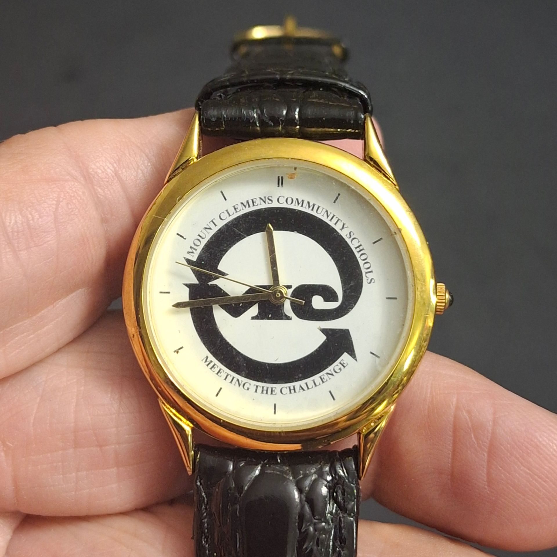 Goldtone Promotional Watch For Mount Clemons Community Schools "Meeting The Challenge" Stainless Steel Back, Japan Movt & Faux Black Leather Strap, Ha