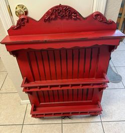 country farmhouse style cherry red wall shelf features black distressed edges and a carved rose swag topper.