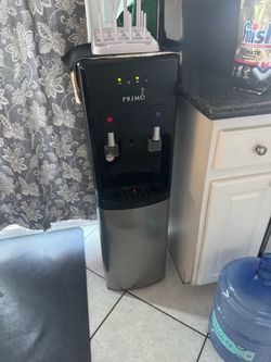 Primo Top-Load Water Dispenser with 4 of 5 gallons jugs for ($35)