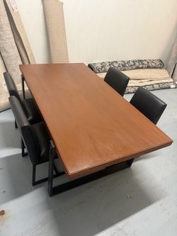 Nice wood dining table with black leather chairs