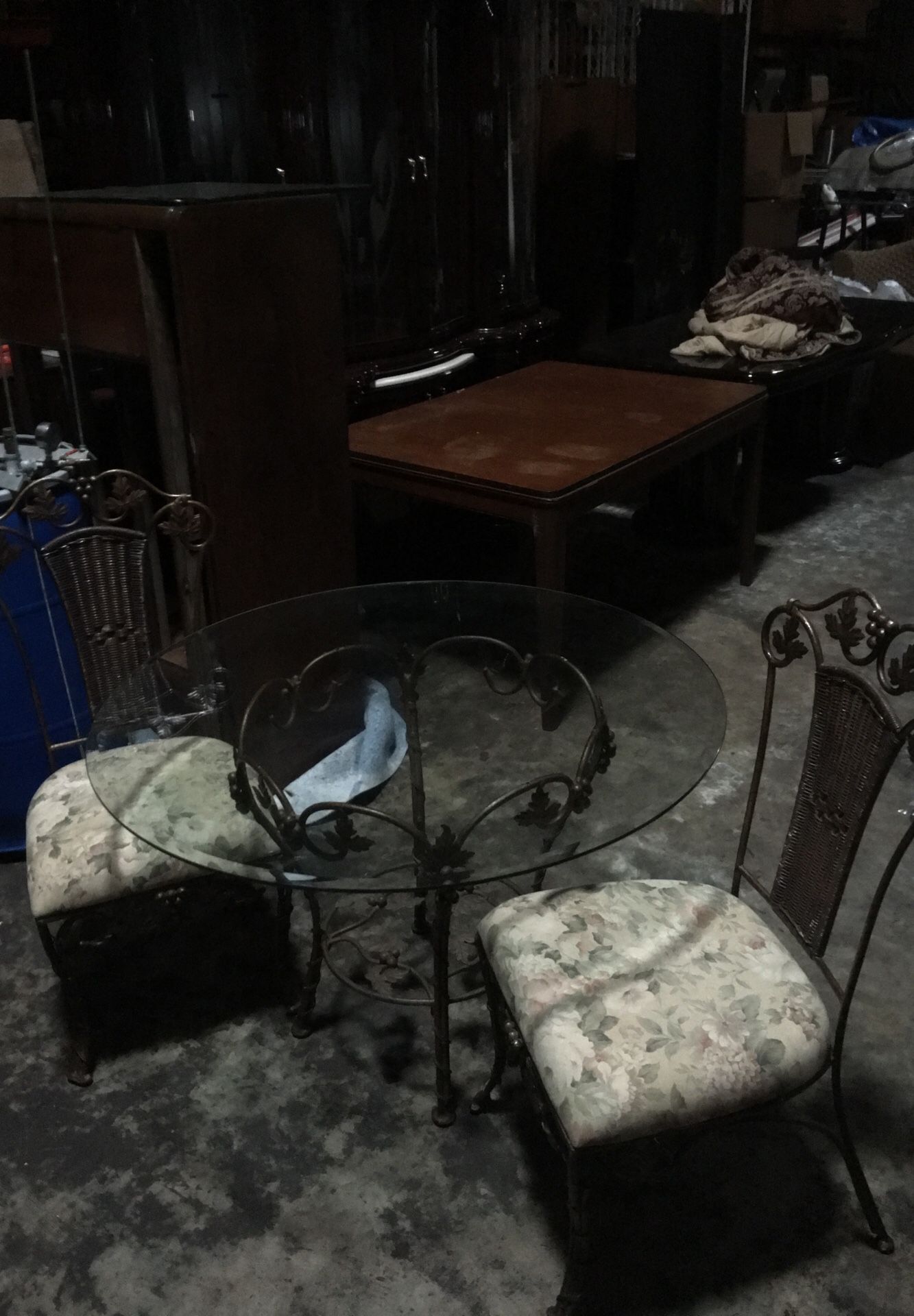 Glass topped table with 2 wrought iron chairs.
