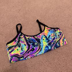 Vibrant neon marble print crop top by iHeartRaves. Slim, supportive fit with thin black straps. Smooth, stretchy fabric for easy movement. Bold multic