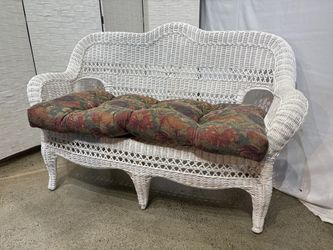White Wicker Loveseat with Arched Backrest and Floral Cushion