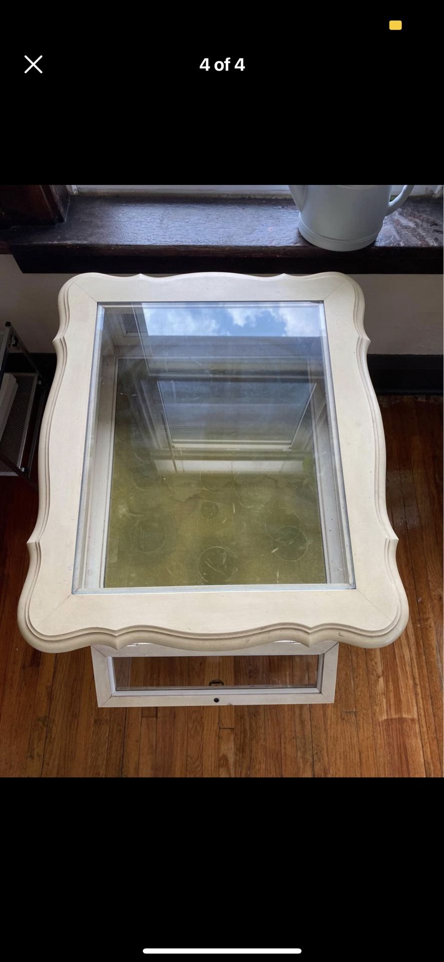 Cream Colored Wooden Table With Glass Top And Opening Cupboard
