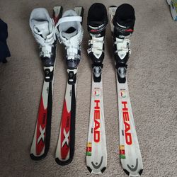 Two Sets Of Skis With Boots