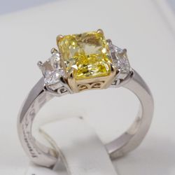 New Radiant Cut Fancy Yellow 3 stone Diamond Ring.  Centerstone 2.5 Carat. Trapezoid side stones weigh .75 carats