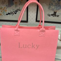 Bubble gum Pink felt tote  lucky written across front  2 handles  Measures 15.5”