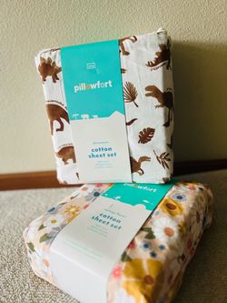Brand new Pillowfort cotton sheet sets, still in the original packaging. One has a cute dinosaur design and the other has a beautiful vintage floral d