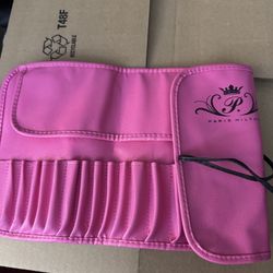 Hot pink faux-leather brush holder with elastic slots, branded with “Paris Hilton” logo. Compact and travel-friendly.
