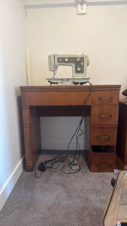 This is a vintage Kenmore sewing machine in a wooden cabinet.