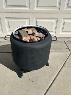 Fire Pit made from washing machine tub with legs, handles and firewood