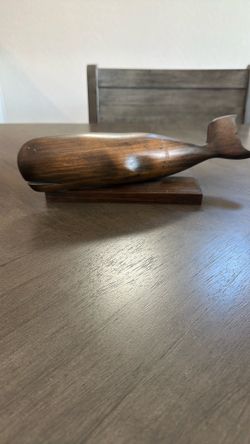 vintage ironwood whale sculpture resting on a matching solid wood base