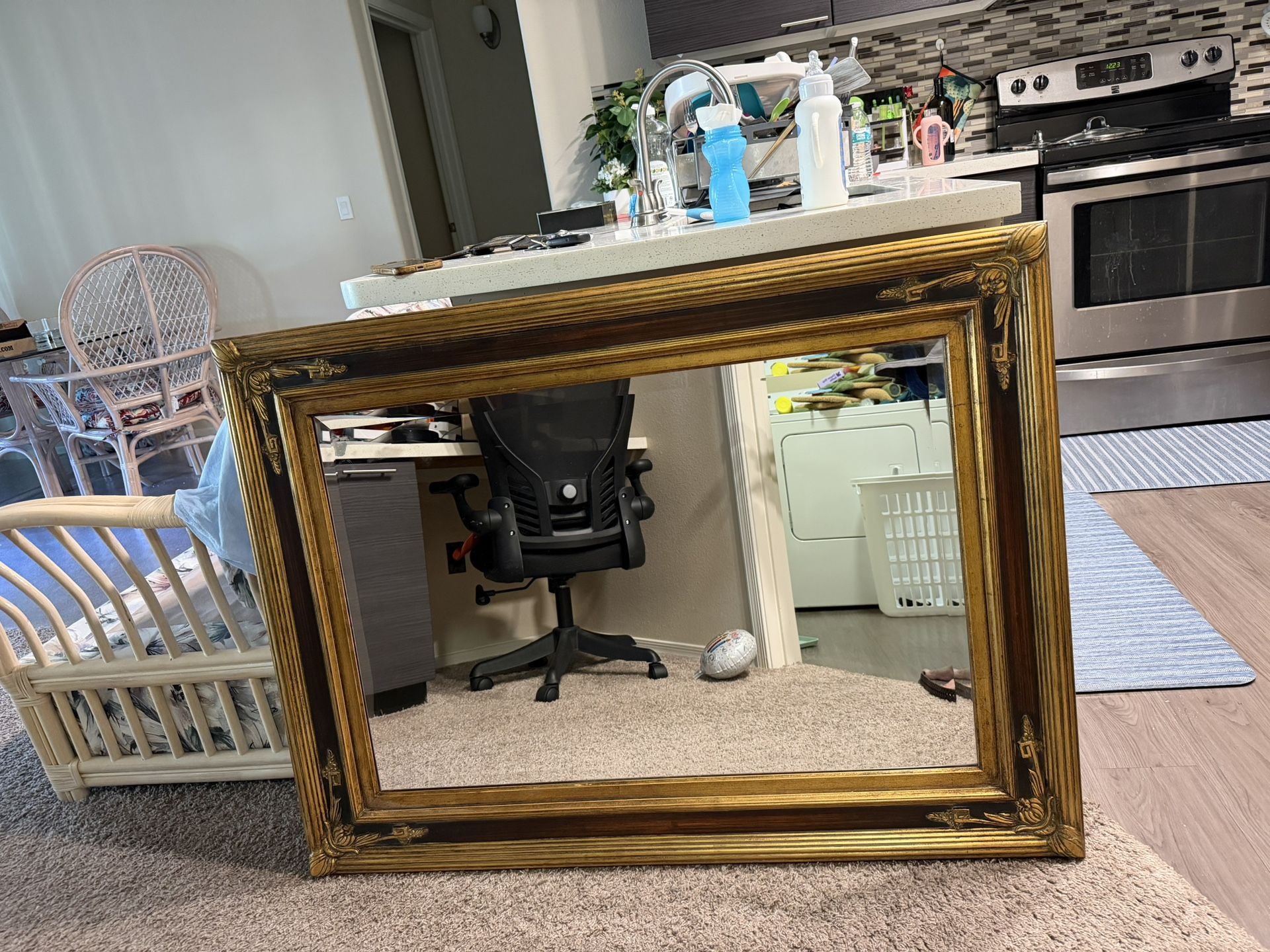     This is a large, ornate, antique-style gold-framed mirror, possibly in a Victorian Style