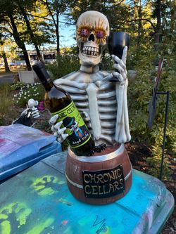Used skeleton chronic wines store display has piece of one thumb chipped off but still holds bottle