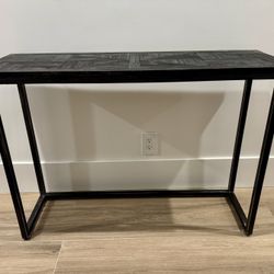 Console table made of solid acacia and mango wood with a black finish and a powder-coated steel frame
