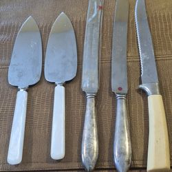 Three stainless steel wedding cake, knives, and two stainless steel servers