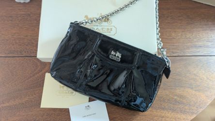 Coach Madison patent leather wristlet in black, featuring a silver chain strap.