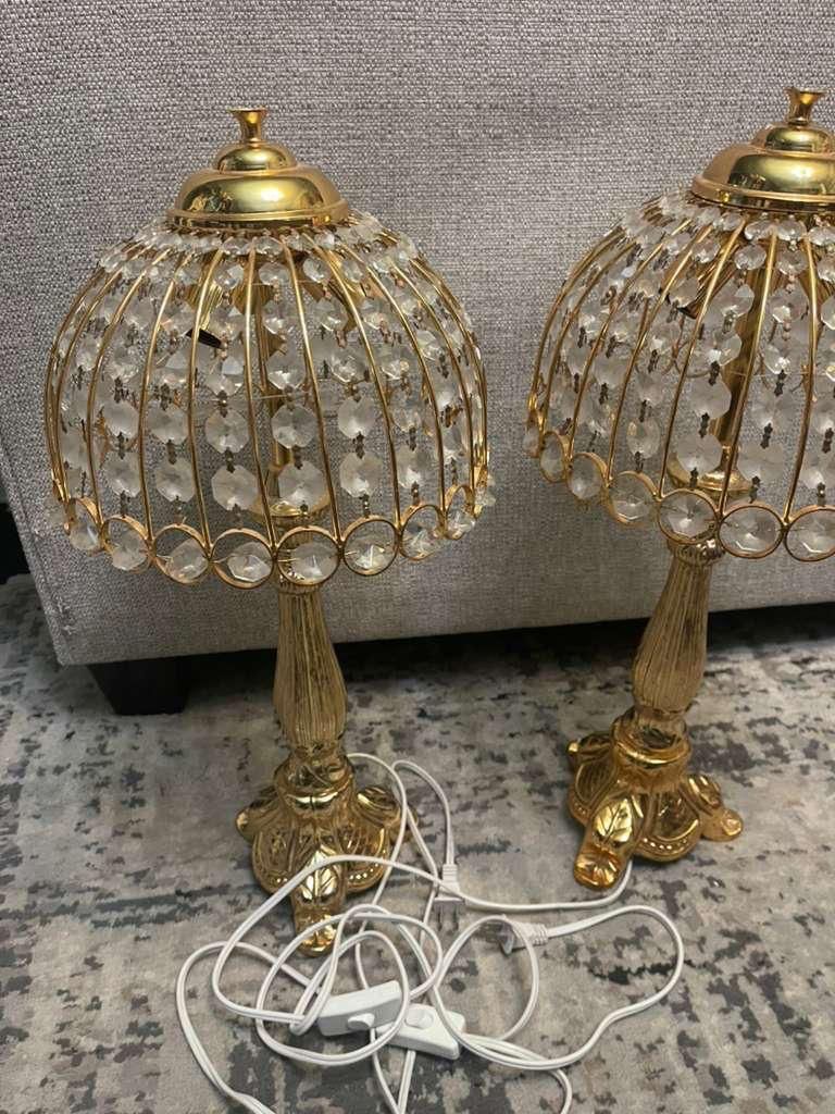 pair of gold and crystal table lamps, likely in a vintage or French Empire style. The design features a gilded metal base and a shade constructed of a