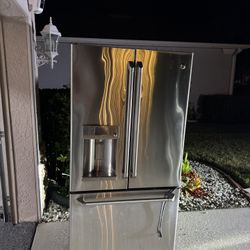 GE General Electric stainless steel French door fridge with a bottom freezer and built-in water/ice