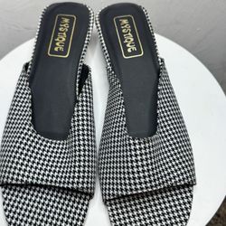 These are women's flip-flops with a houndstooth pattern from the brand Mystique.