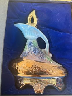 vintage 1977 Jim Beam "185 Months" ceramic whiskey decanter featuring a blue and iridescent gold-lustre finish with sculpted grape
