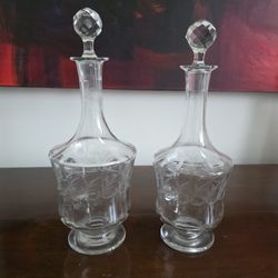 Pair of cut glass decanters with faceted stoppers and etched grapevine design