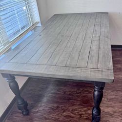 Gorgeous solid wood farmhouse-style, large kitchen table in a weathered gray finish with distressed black legs. New condition. Barely used for less th