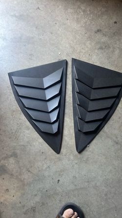 Matte black rear quarter window louvers or side vent scoop covers.