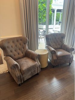 Gorgeous Pair of A classic push-back reclining armchairs w/ diamond-button tufting, rolled arms, a high winged back, and silver/copper nailhead trim. 
