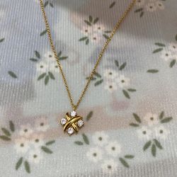 Tiffany & Co. Cross-Wrapped Pendant Necklace Featuring Four Sparkling Diamonds. 