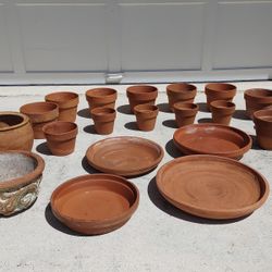Preowned bunch of clay flower pots and saucers