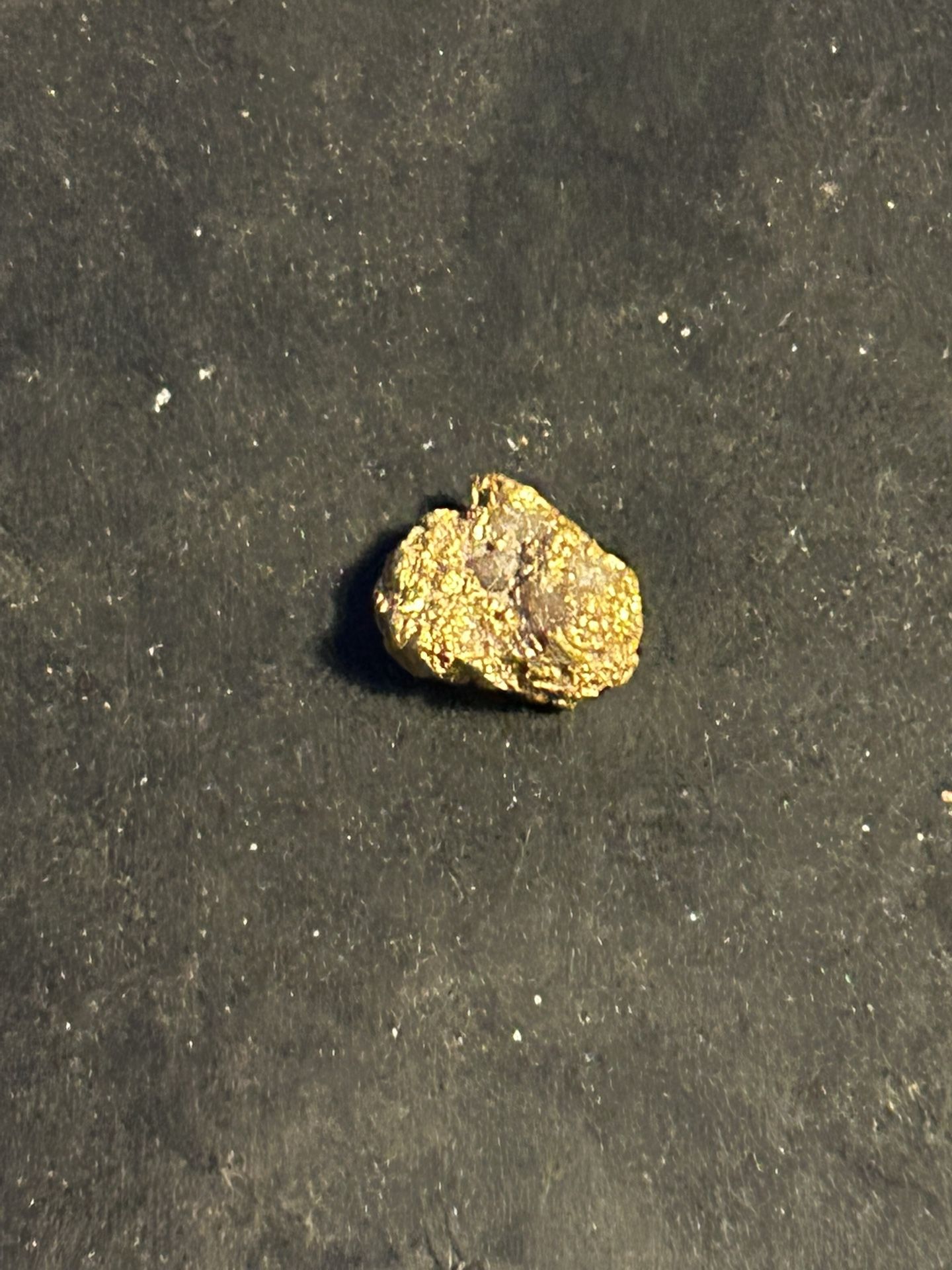 A solid gram of gold with quartz in it laying at 1.2 g