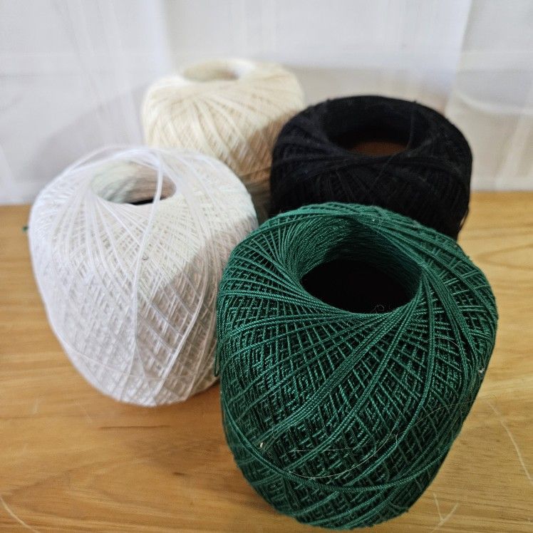 Cotton crochet/knitting yarn skeins. Black,green, ivory and white colors.