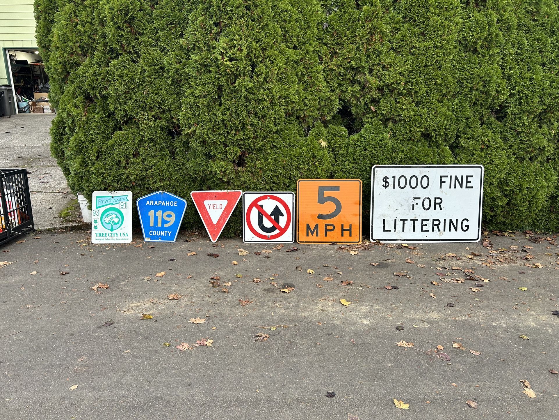 Various metal road signs perfect for decorating the yard or man cave. The largest sign on the far right measures 3 feet tall and 5 feet wide for pers