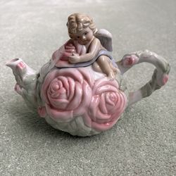 1998 Avon collectible teapot featuring a 3-D cherub on the lid and cabbage rose floral pattern