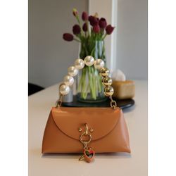 Elegant burnt orange handbag with pearl handle