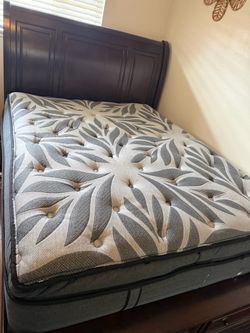 Queen sleigh bed with two drawers at the footboard .