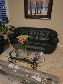 Green leather sofa and glass table
