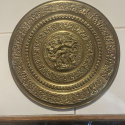 vintage Indian brass plate featuring a repoussé depiction of the Hindu deity Shiva Nataraja, the Lord of the Dance.  The plate is crafted from brass a