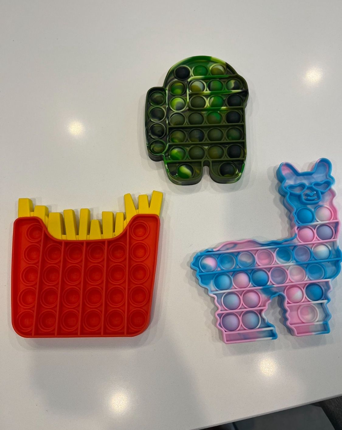 Set Of Pop It Fidget Toys. Llama/Alpaca, French Fries, Among Us Spaceman. French fries, among us space man and lama/alpaca pop it toys. Great for anxi