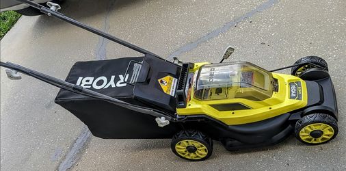 Cordless Ryobi ONE+ 18V lawn mower has a yellow and black plastic body with a rear grass catcher bag.