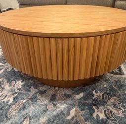Round Wood Coffee Table with Fluted Base. Lifts up and has storage space. Like new